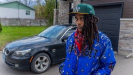 Khadafi Keenan Fagan-Pierre stands near the spot where he was questioned by police on April 14, with his father's BMW E60 535 in the background. (Michel Aspirot/CBC)
