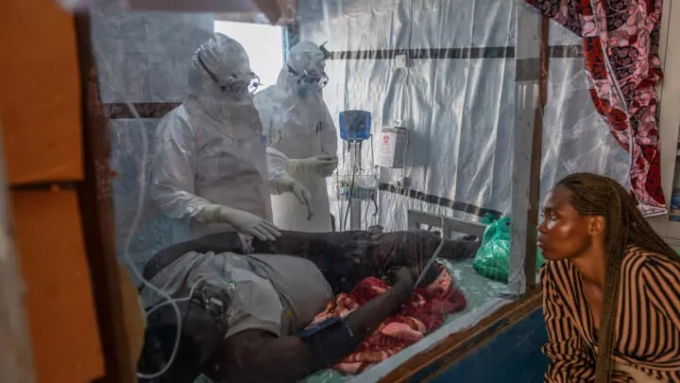 Health workers tend to an Ebola patient at the Rwampara Treatment Center in Ituri, DR Congo, Thursday, June 18, 2026. © Moses Sawasawa, AP
