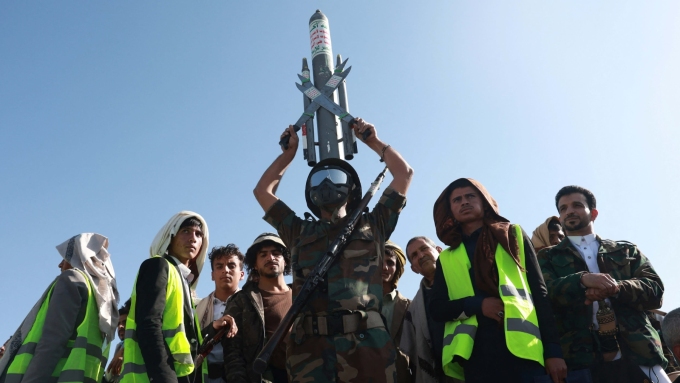 A Houthi supporter in military uniform holds a mock missile above his head in Sana’a, Yemen © Mohammed al-Mahdi/Reuters