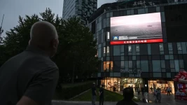 An outdoor screen shows a news coverage of China's military drills around Taiwan, in Beijing on May 23, 2024. © Jade Gao, AFP