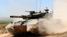 An Israeli army battle tank moves near the border with the Gaza Strip at a location in southern Israel on May 15, 2024, amid the ongoing conflict in the Palestinian territory between Israel and the Hamas movement. (Photo by JACK GUEZ / AFP)