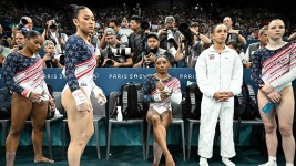 Simone Biles (centre) and teammates are seen during the artistic gymnastics women's team final during the Paris 2024 Olympic Games. (Photo by Lionel Bonaventure/AFP)