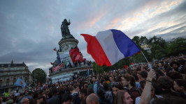 A French national tricolour waves during an election night rally following the second round of France's legislative elections at Place de la République on July 7, 2024. © Emmanuel Dunand, AFP