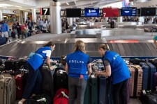 Delta workers sort through luggage at a baggage claim. Photo: Christian Monterrosa/Bloomberg News