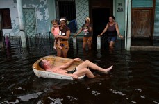 A man rides a handmade raft through a flooded street in Batabano, Mayabeque province, Cuba YAMIL LAGE/AFP