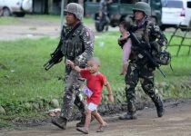 Filipino soldiers hold on to fleeing children following reports of fresh clashes between government troops and rebels in Marawi City, Mindanao Island, southern Philippines, on May 25.Linus G. Escandor II / EPA