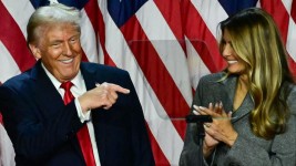 Donald Trump points to his wife former US First Lady Melania Trump during an election night event at the West Palm Beach Convention Center in West Palm Beach, Florida, early on November 6, 2024. (Photo by Jim WATSON / AFP)