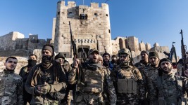 Syrian militants stand in front of the Ancient Castle of Aleppo after seizing control of most parts of Syria's second largest city on 30 November 2024, Aleppo, Syria. ©  Anas Alkharboutli / picture alliance via Getty Images