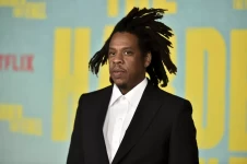 Jay-Z, in a suit, is photographed at a movie screening. Jay-Z arrives at a screening of “The Harder They Fall” at the Shrine Auditorium in Los Angeles in October 2021. (Richard Shotwell / Invision / AP)