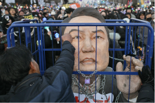 Un manifestant appelant au limogeage du président Yoon Suk-yeol frappe une effigie du chef de l'État à Séoul, le 14 décembre 2024. © Anthony Wallace, AFP archives