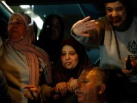 Palestinians freed from Israeli prison wave to the crowd from a Red Cross bus on the outskirts of Ramallah, in the Israeli-occupied West Bank, early Monday. (John Wessels/AFP/Getty Images)