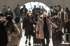 This photo taken on December 10, 2022 shows passengers wearing face masks amid the Covid-19 pandemic arriving at Hankou Railway Station in Wuhan in China's central Hubei province. | STR/AFP via Getty Images