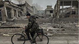 Un homme se déplace à vélo devant le bureau de poste qui a été détruit par une frappe aérienne russe à Kourakhové, dans la région de Donetsk, en Ukraine, le 7 novembre 2024. © Anton Shtuka, AP