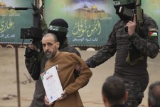 Israeli captive Eli Sharabi, who has been held hostage by Hamas in Gaza since Oct. 7, 2023, is escorted by Hamas fighters before being handed over to the Red Cross in Deir al-Balah, central Gaza Strip, on Saturday Feb. 8, 2025. Abdel Kareem Hana—AP