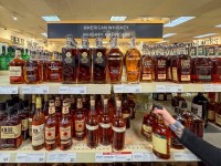 A worker places bottles of American whiskey into a shopping cart to fill an order for a restaurant, at a Liquor Control Board of Ontario (LCBO) store in Hamilton, Ontario, Canada February 2, 2025. REUTERS/Carlos Osorio