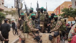 Hamas fighters patrol a street before they handover three Israeli hostages to a Red Cross team in Deir el-Balah, central Gaza, on February 8.  Eyad Baba/AFP/Getty Images