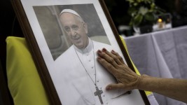 A woman touches a portrait of Pope Francis on February 24, 2025, in Buenos Aires, Argentina.  John Moore/Getty Images