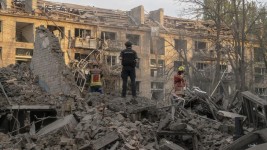 Des policiers et des membres du service d’urgence de l’État sur le site où trois missiles ont frappé un quartier résidentiel de Kiev. Albert Lores pour Le Figaro