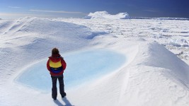 A person stands on an ice sheet in the Antarctic.