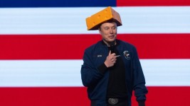 Tech businessman Elon Musk arrives for a town hall wearing a cheesehead hat at the KI Convention Center on March 30, 2025 in Green Bay, Wisconsin. ©  Scott Olson / Getty Images