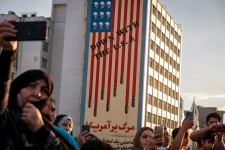 Iranian families capture videos with their cellphones while standing under an anti-U.S. mural during a religious festival in Tehran, Iran, on May 9, 2025. Morteza Nikoubazl—Getty Images