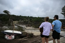 People look on as law enforcement and volunteers continue to search for missing people near Camp Mystic in Hunt, Texas, on July 5. Photographer: Ronaldo Schemidt/AFP/Getty Images