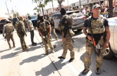 An unmasked ICE agent keeps an eye out after being surrounded by an angry crowd after an ICE raid on Atlantic Boulevard in the city of Bell on June 20. (Genaro Molina / Los Angeles Times)