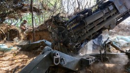 Ukrainian soldiers fire a US-made M777 howitzer on July 24, 2024. ©  Scott Peterson / Getty Images