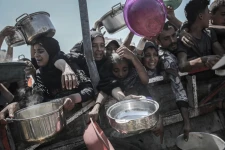 Palestinians try to collect free food from a charity kitchen in Gaza City.  Photographer: Ahmad Salem/Bloomberg