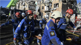 Ukrainian rescuers carry the body of a victim recovered during a search and rescue operation at the site of a residential building heavily damaged following a Russian missile strike in Kyiv on August 28, 2025. © Genya Savilov, AFP