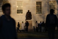 People gather to take photos with the John Harvard Statue at Harvard University in Cambridge, Massachusetts on April 17. Sophie Park/Getty Images