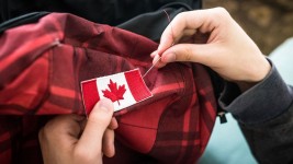 Canadians sew flags onto their luggage to make sure everyone knows they're Canadian. They don't love it when Americans do it.  Danielle Donders/Moment RF/Getty Images/File