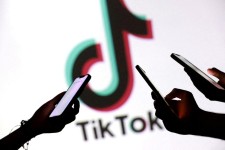 Une photo d’illustration d’adolescents posant avec leur téléphone devant le logo du réseau social TikTok à Zenica (Bosnie-Herzégovine), le 11 septembre 2025. DADO RUVIC/REUTERS