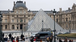 Police stand near the pyramid of the Louvre museum after reports of a robbery, in Paris on Sunday. (Gonzalo Fuentes/Reuters)