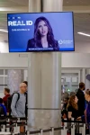 Secretary of Homeland Security Kristi L. Noem is seen on a video monitor Friday at Hartsfield-Jackson Atlanta International Airport. (Erik S Lesser/EPA/Shutterstock)