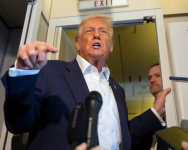 Donald Trump speaks to reporters onboard Air Force One. Photograph: Mark Schiefelbein/AP