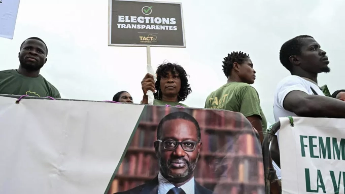 Des manifestants arborent une bannière du président du Parti démocratique de Côte d'Ivoire (PDCI), Tidjane Thiam, à Abidjan le 31 mai 2025, avant l'élection présidentielle du 25 octobre 2025. © Sia Kambou, AFP