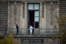 A French forensics officer examined the cut window and balcony at the scene of the Louvre robbery. Kiran Ridley/Getty Images