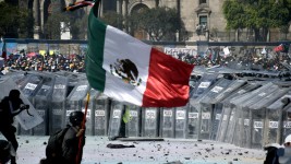 A protester waves a Mexican flag during a demonstration on November 15, 2025, in Mexico City, Mexico. ©  Johana Remigio / Obturador MX / Getty Images