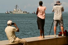 People watch the USS Gravely depart the Port of Spain in Trinidad and Tobago on October 30. The warship arrived in Trinidad and Tobago on October 26, for joint exercises near the coast of Venezuela, as the Trump administration ratcheted up pressure on Ven