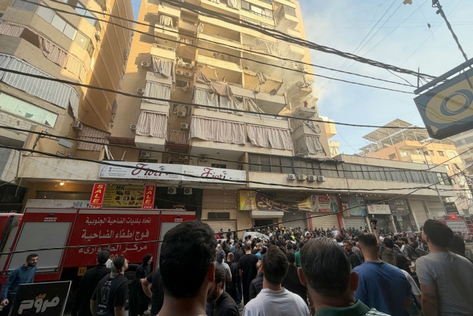 People gather looking at a residential building following an Israeli military strike in Beirut's southern suburbs. Ibrahim Amro/AFP/Getty Images