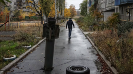 A resident walks past part of a Russian missile in the front-line town of Dobropillia, Ukraine, on Oct. 27. (Anatolii Stepanov/Reuters)