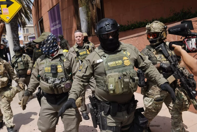 U.S. Border Patrol Commander Gregory Bovino marches with masked federal agents through Little Tokyo in August. (Carlin Stiehl / Los Angeles Times)