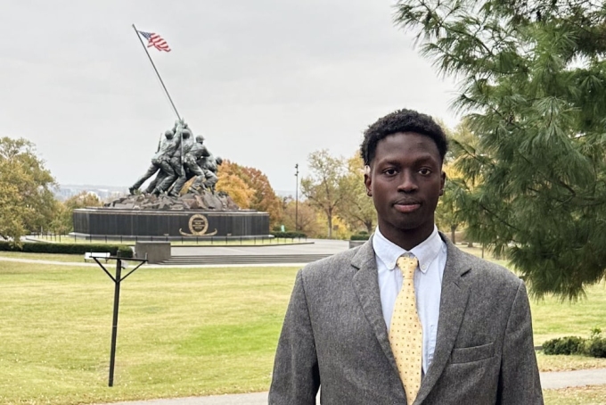 Alex Lomong stands in front of the Iwo Jima Memorial in Arlington, Va., in the suit he wore for his asylum interview.Courtesy Alex Lomong