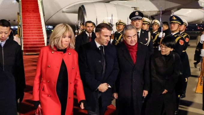 Le ministre des Affaires étrangères chinois Wang Yi reçoit le président français Emmanuel Macron et son épouse Brigitte Macron à leur arrivée à Pékin, le 3 décembre 2025 Ludovic Marin / REUTERS