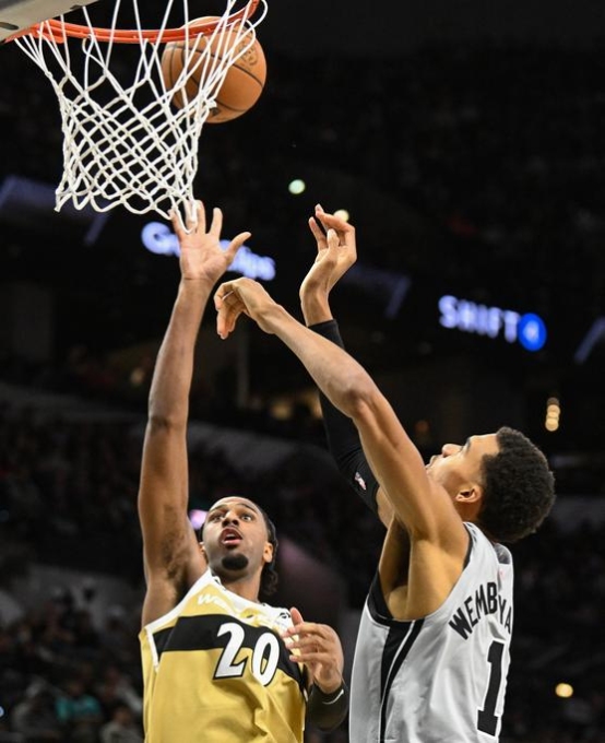 Victor Wembanyama des San Antonio Spurs contre un tir du pivot des Washington Wizards Alexandre Sarr, à San Antonio (Texas), le 18 décembre 2025. BILLY CALZADA / AP