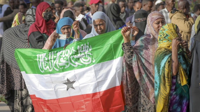 Une femme qui attend pour voter lors de l'élection présidentielle au Somaliland brandit le drapeau du pays, le mercredi 13 novembre 2024.  Photo : Associated Press / Abdirahman Aleeli