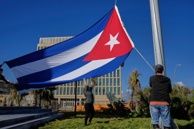 Workers fly the Cuban flag at half-staff outside the U.S. Embassy in Havana, marking the deaths of Cubans killed in the U.S. raid in Venezuela. Ramon Espinosa/AP