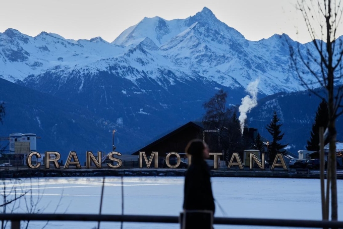 A woman walks in the early morning in Crans-Montana, Swiss Alps, Switzerland, Saturday, January 3, 2026. BAZ RATNER / AP