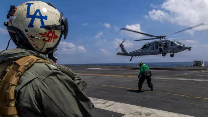 Captain Daniel Keeler, commanding officer of USS Abraham Lincoln, prepares to fly an MH-60R Sea Hawk helicopter in the Indian Ocean on January 23, 2026. © Seaman Daniel Kimmelman, AP